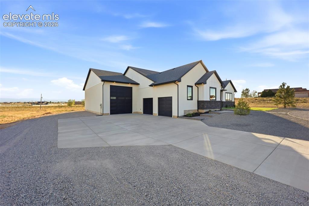 Image 3 of 50: Front of home and side garage entrances 2 car garage and RV garage attached