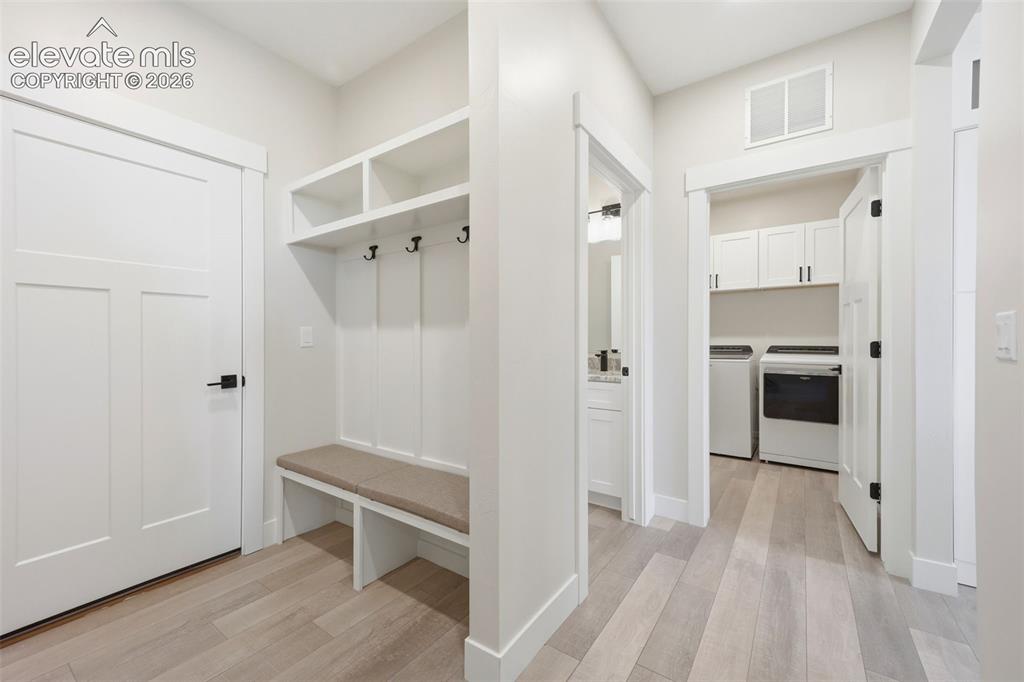 Image 32 of 50: Mudroom, and drop zone with access to garages.