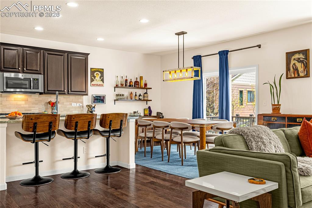Image 10 of 37: Kitchen with dark wood finish cabinetry, dark wood-style floors, tasteful b