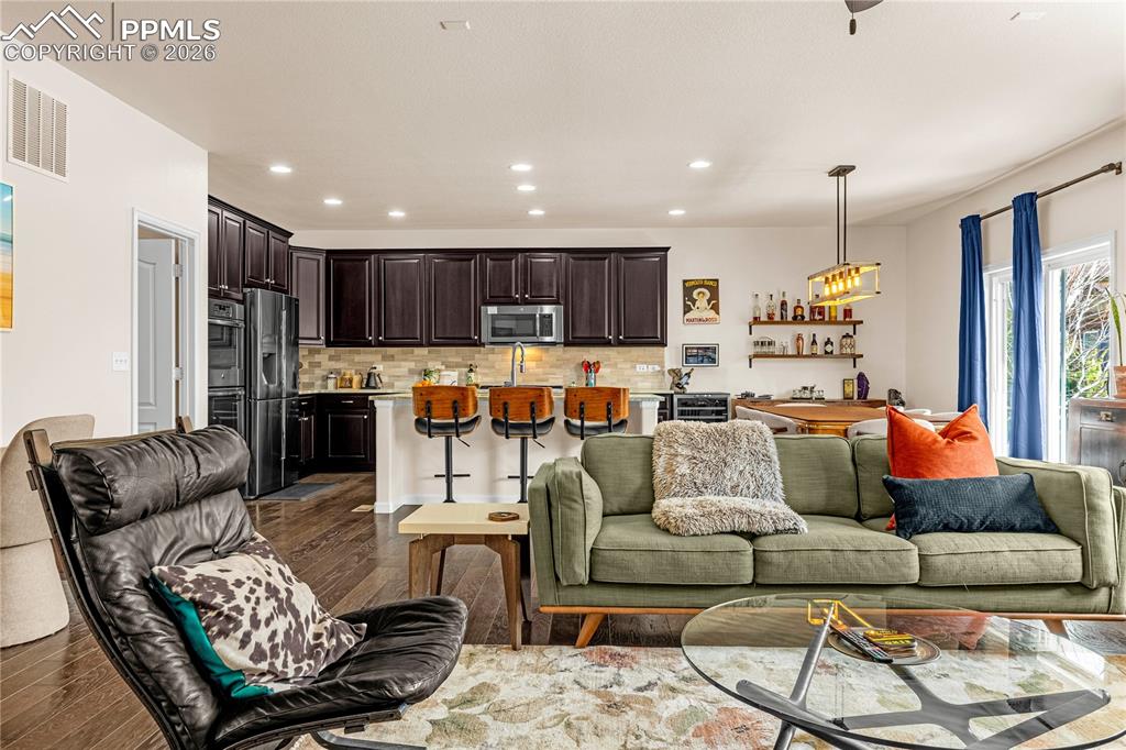 Image 8 of 37: Living room with dark wood finished floors and recessed lighting