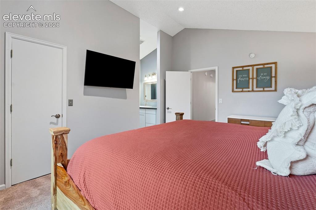 Image 18 of 37: Vaulted ceiling, recessed lighting, wall-mounted television, and wood-finis