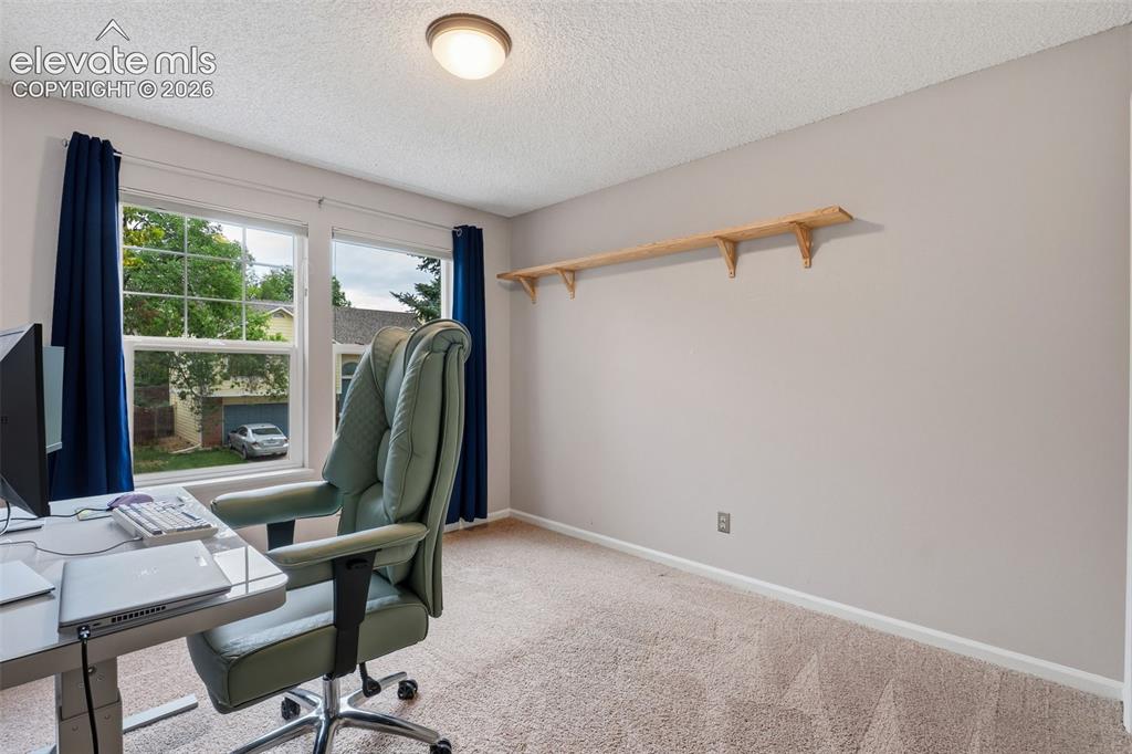 Image 23 of 37: Twin windows with white frames, wall-mounted wooden shelving, and neutral t