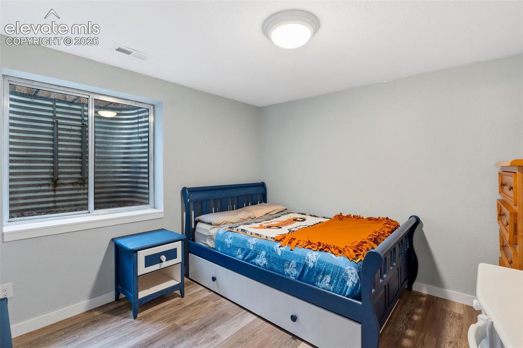 Image 25 of 37: Recessed window with metal window well, wood-finish flooring, and overhead