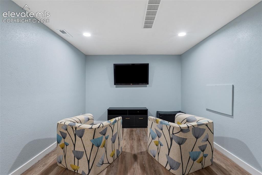 Image 27 of 37: Recessed ceiling lighting, wood-finish flooring, and light blue wall finish