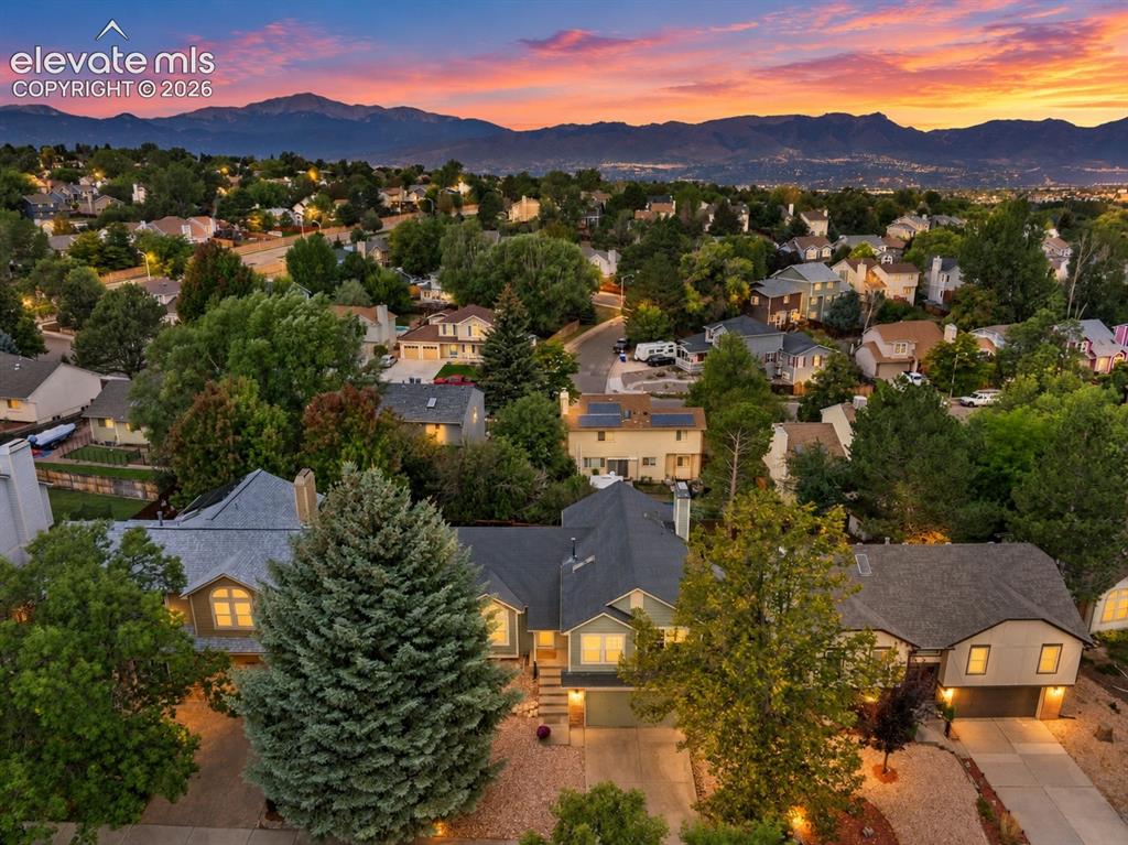 Image 3 of 37: Expansive neighborhood setting with mature trees and mountain scenery