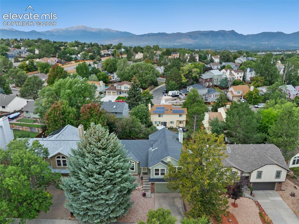 Image 34 of 37: Mountain backdrop with established residential landscaping