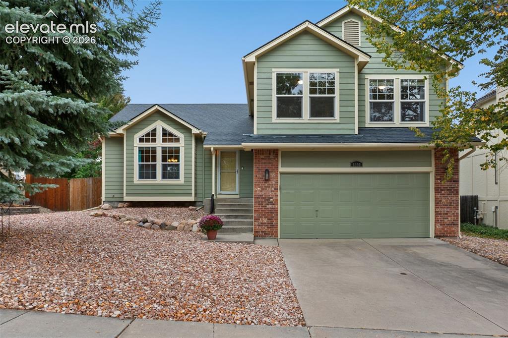 Image 37 of 37: Two-story exterior with light green siding and brick accents