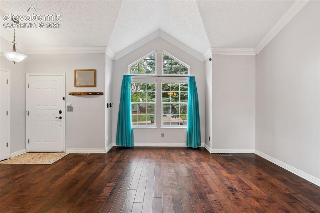Image 6 of 37: Vaulted ceiling with an architectural window, dark wood-finish flooring, an