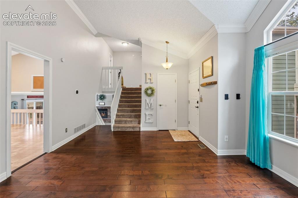 Image 7 of 37: Wood-finish flooring throughout, vaulted ceiling, and an integrated stairca