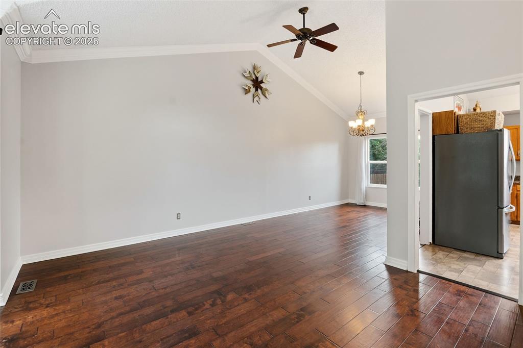 Image 8 of 37: Vaulted ceiling featuring a ceiling fan, crown molding, and wood-finish flo