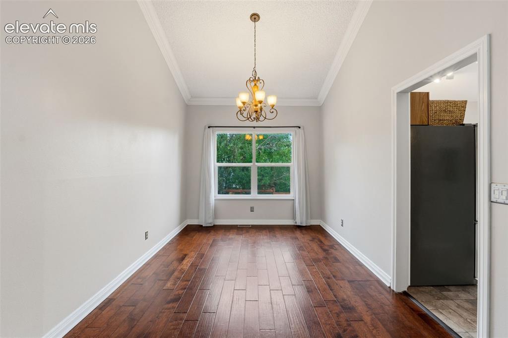 Image 9 of 37: Elegant formal dining room showcasing rich wood-finish flooring in a herrin