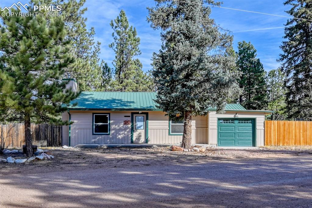 Image 1 of 43: Ranch-style home featuring a metal roof, a garage, driveway, and a standing