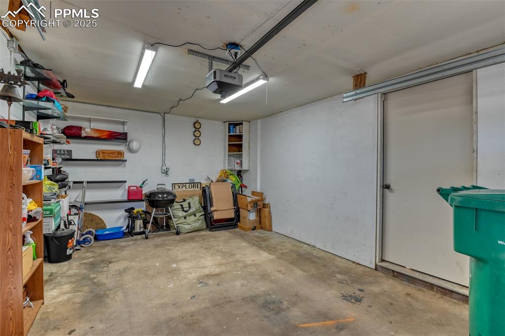 Image 19 of 42: Garage featuring a garage door opener