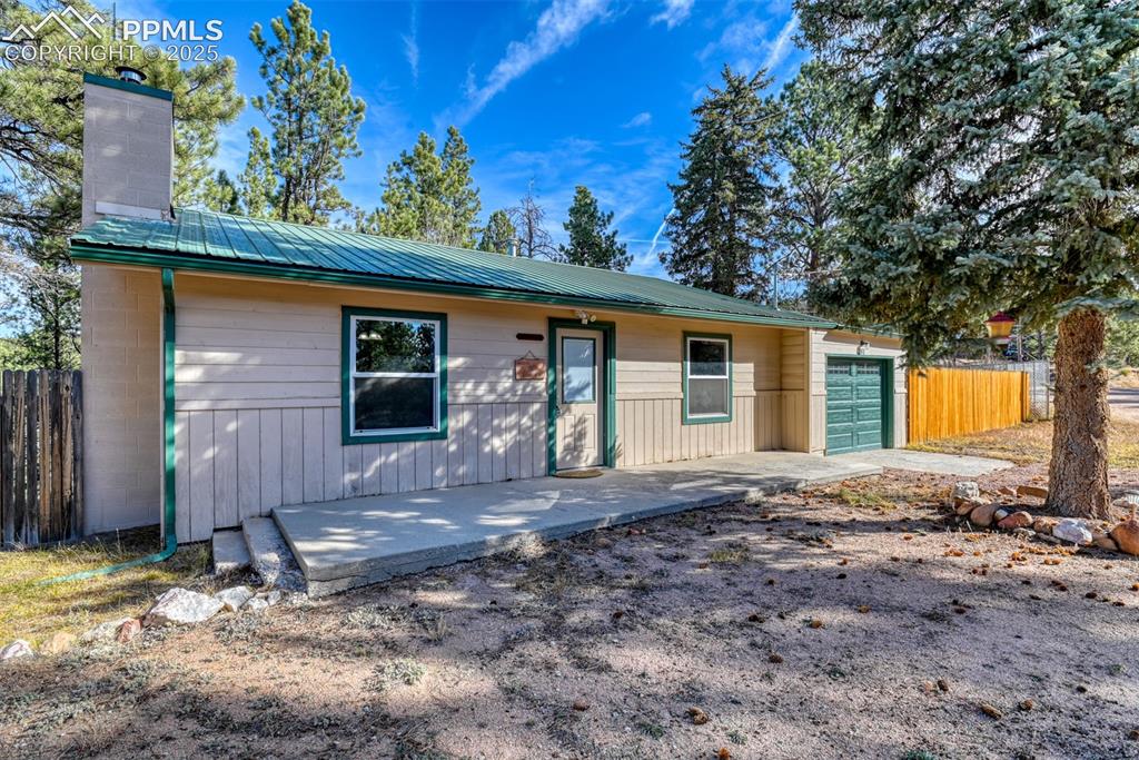 Image 2 of 43: Ranch-style house with a metal roof and a chimney