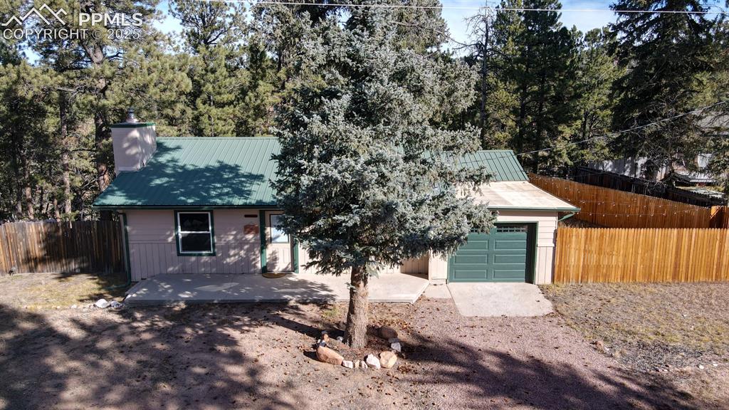 Image 4 of 43: View of front of home featuring a metal roof and a chimney