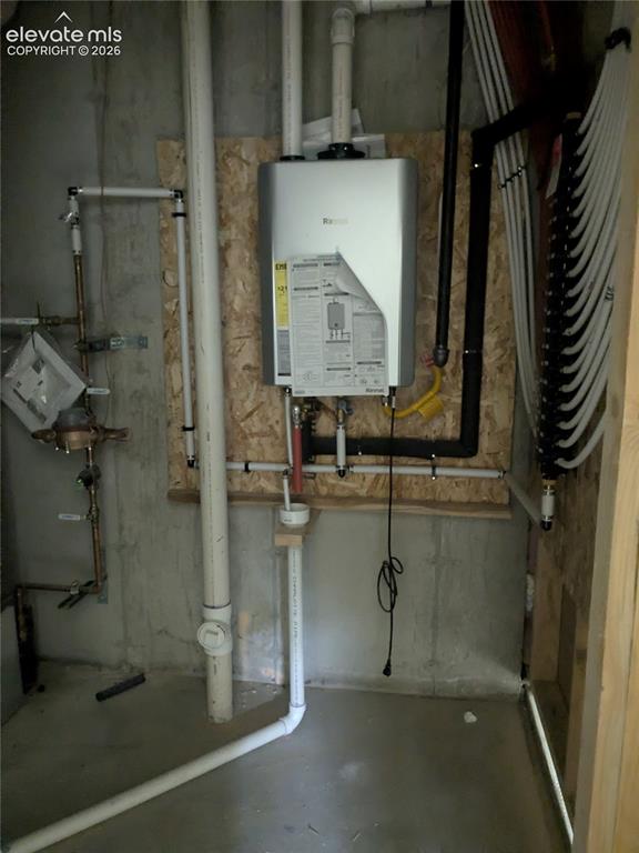 Image 33 of 45: Wall-mounted tankless water heater with visible plumbing and conduit