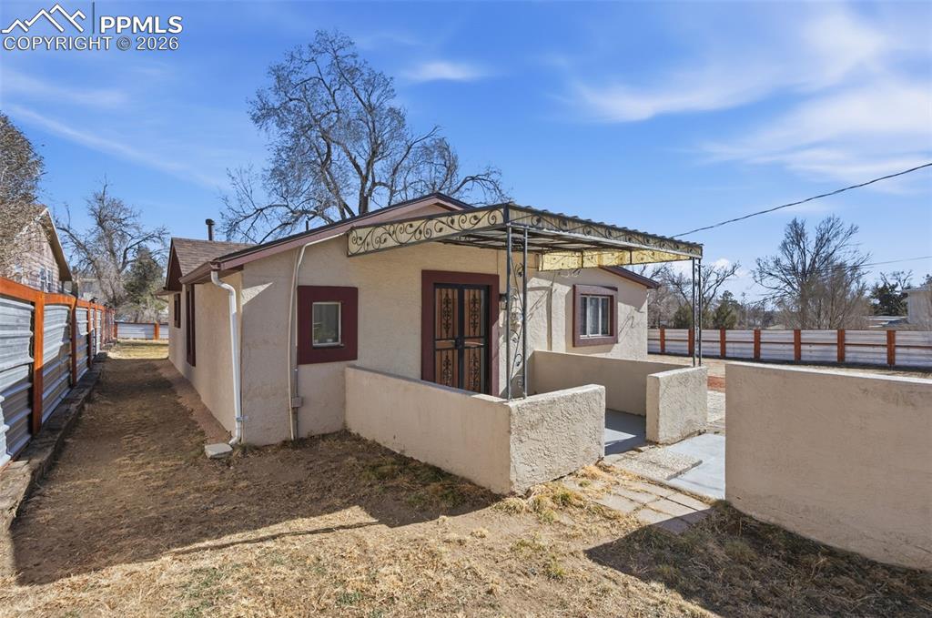 Image 29 of 50: A nice view of the covered smaller backyard patio and north side of the hou