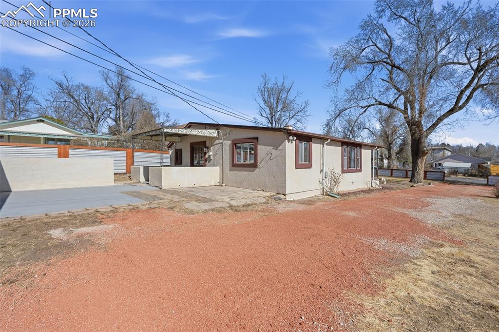 Image 42 of 50: A view from the garage of the back of the primary house and patios.