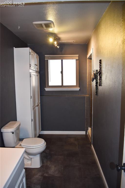 Image 12 of 24: Bathroom with toilet, a textured ceiling, baseboards, and visible vents