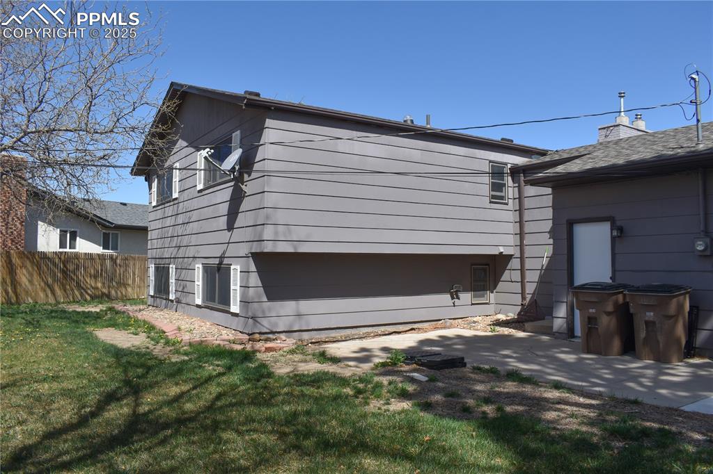 Image 17 of 24: Back of house featuring a yard and fence