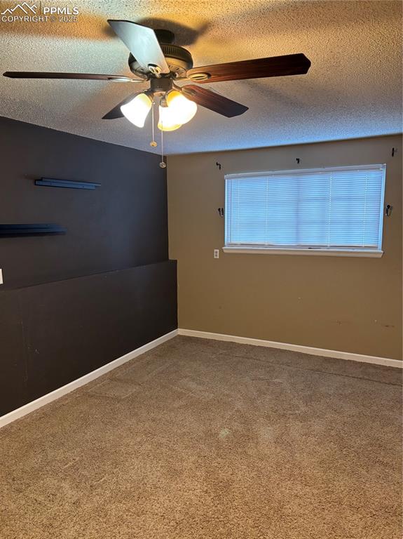 Image 20 of 24: Spare room featuring baseboards, a ceiling fan, carpet floors, and a textur