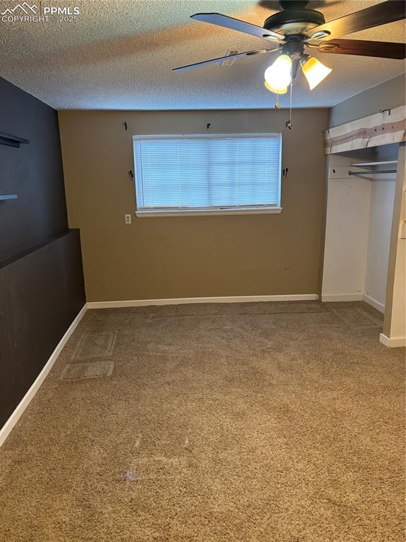 Image 21 of 24: Unfurnished bedroom featuring a closet, carpet, baseboards, and a textured