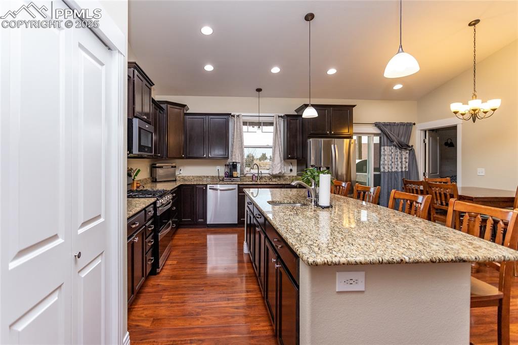 Image 9 of 46: Kitchen with granite counters, gas range and an island with sink