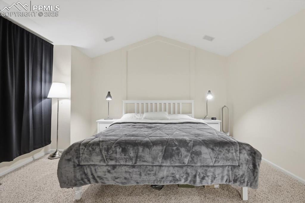 Image 20 of 32: Upper level primary suite with vaulted ceilings.