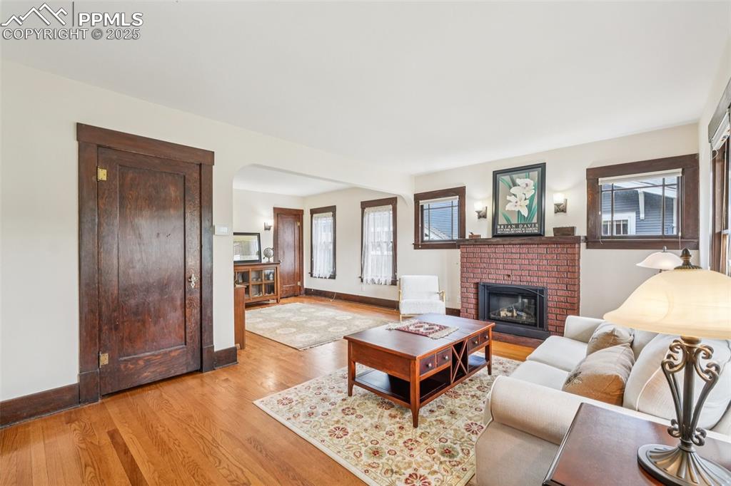 Image 10 of 49: Living room featuring plenty of natural light, a fireplace, light wood-styl