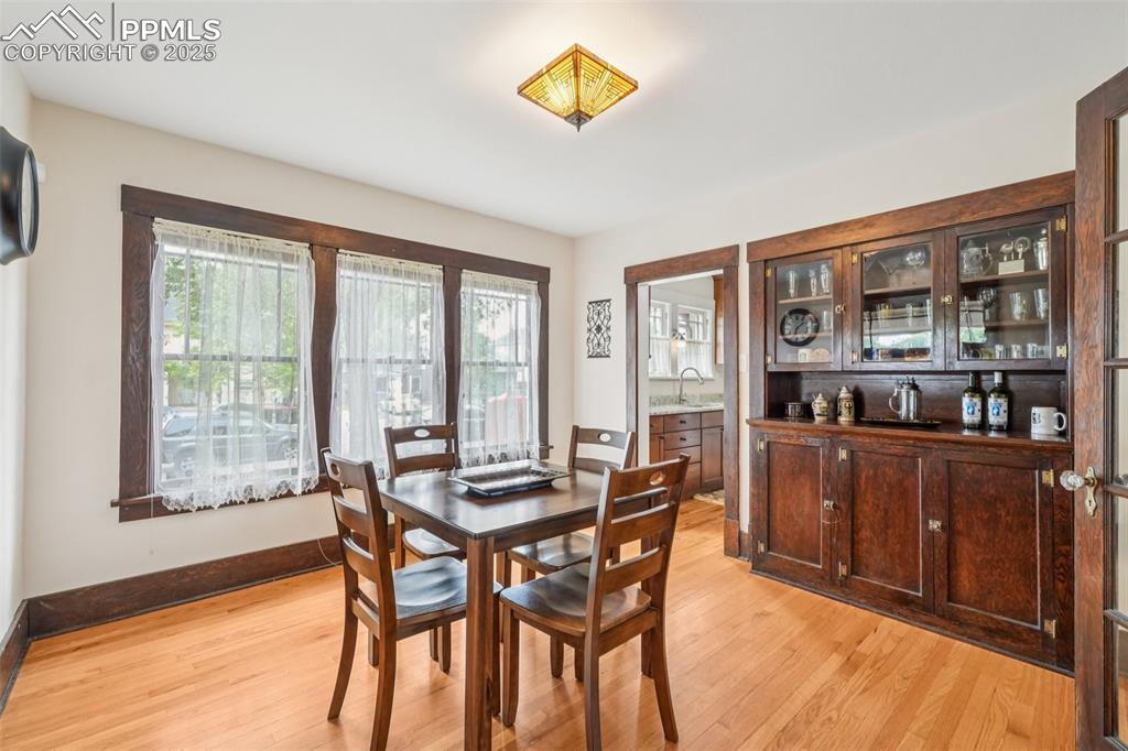 Image 14 of 49: Dining room with light wood-style flooring, built-in cupboard, and baseboar