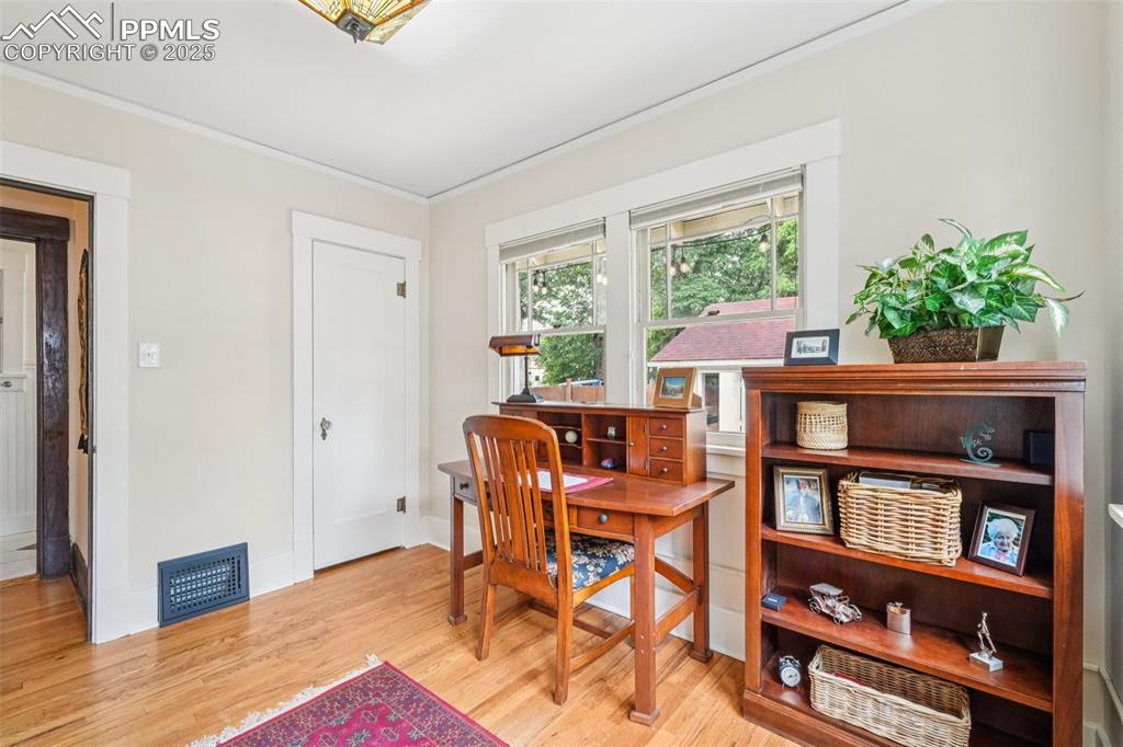Image 22 of 49: Office with ornamental molding and wood finished floors