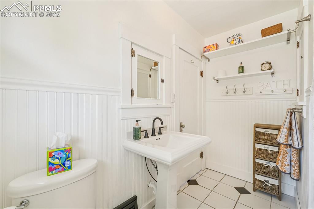 Image 24 of 49: Bathroom with wainscoting and tile floors