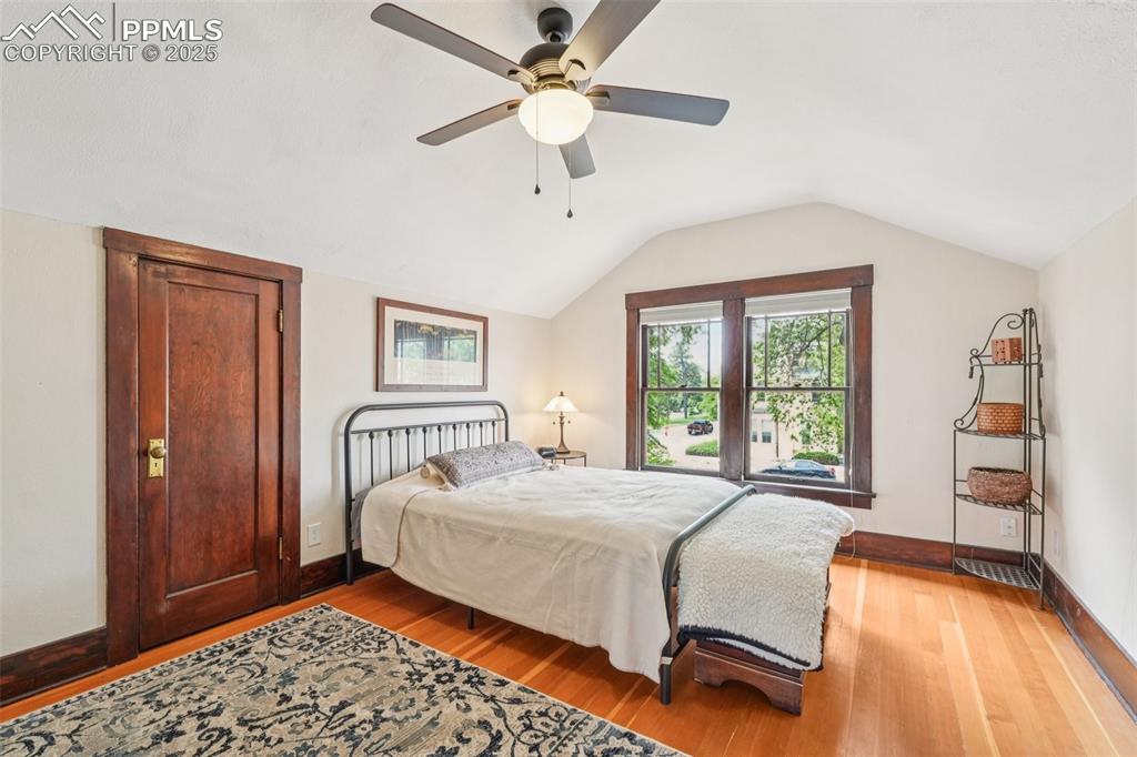 Image 29 of 49: Bedroom with light wood-style floors, lofted ceiling, extra closets, and a 