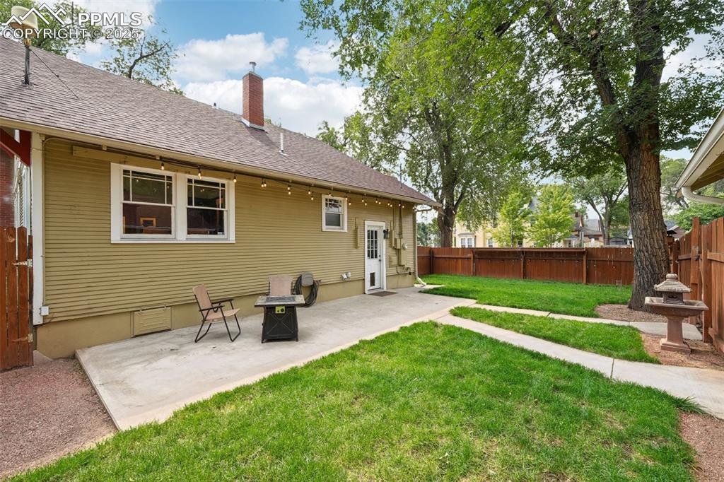 Image 40 of 49: Fenced backyard with  patio