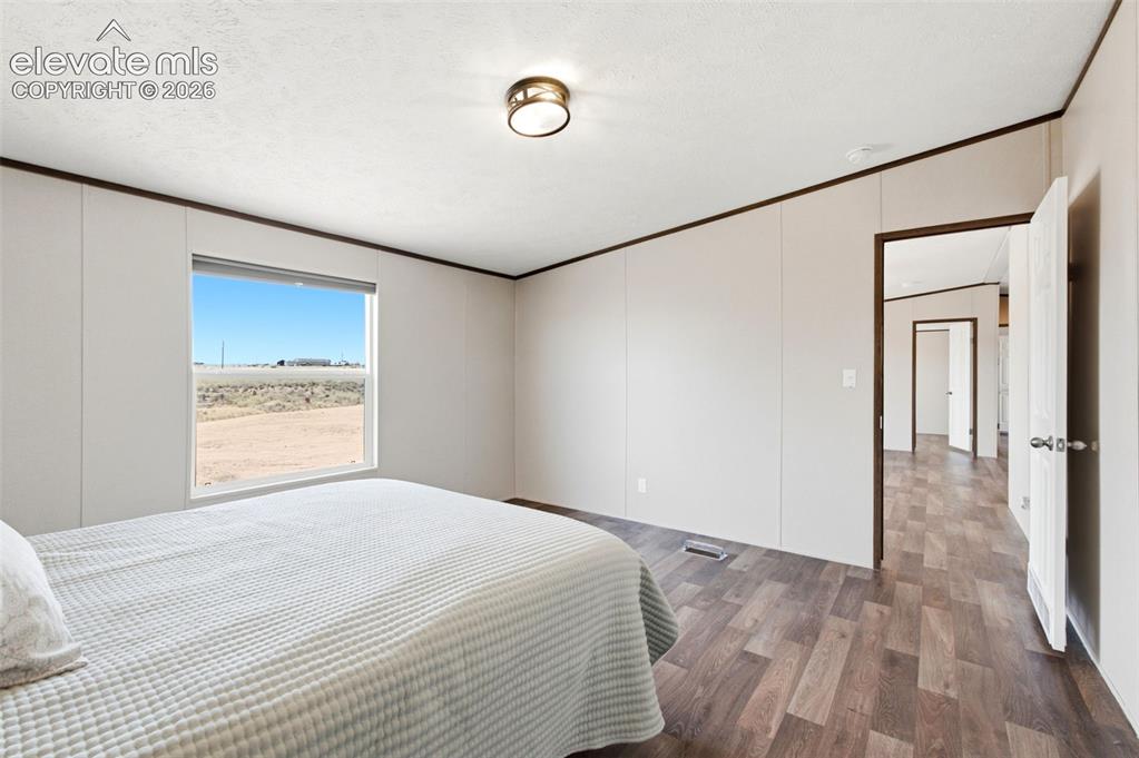 Image 10 of 32: Bedroom featuring a window with natural light, wood-finish flooring, and a