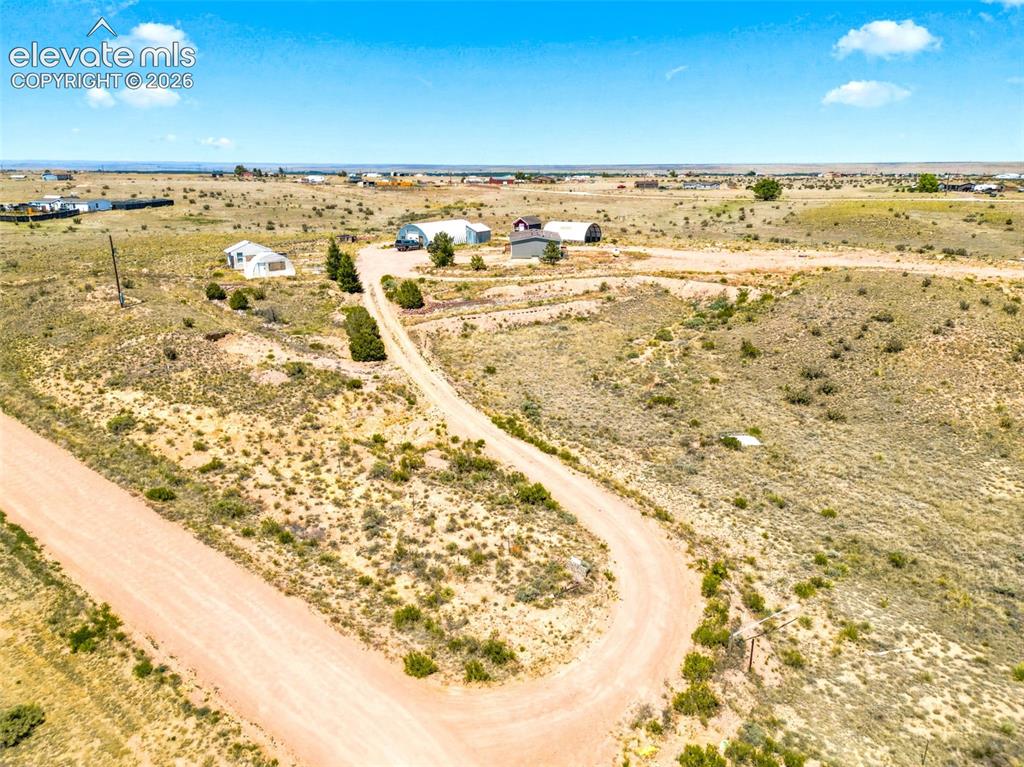Image 26 of 32: Expansive natural landscape with a gravel road winding through the terrain
