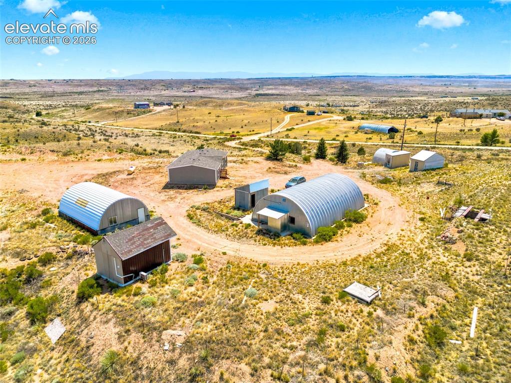Image 29 of 32: Expansive property featuring multiple quonset hut structures, additional ou