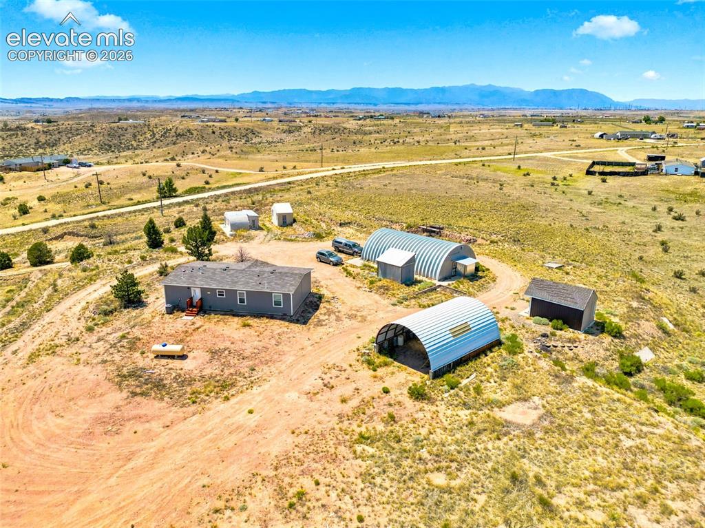 Image 30 of 32: Expansive property featuring a single-story residence, two large arched met