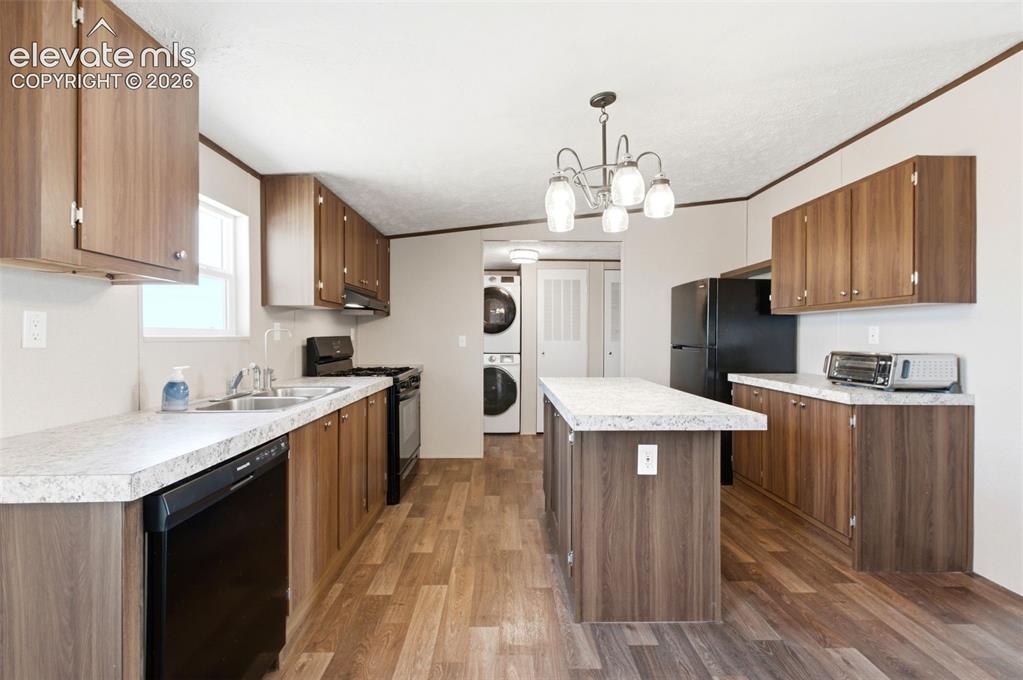 Image 7 of 32: Kitchen featuring wood-finish cabinetry, light-toned countertops, a central