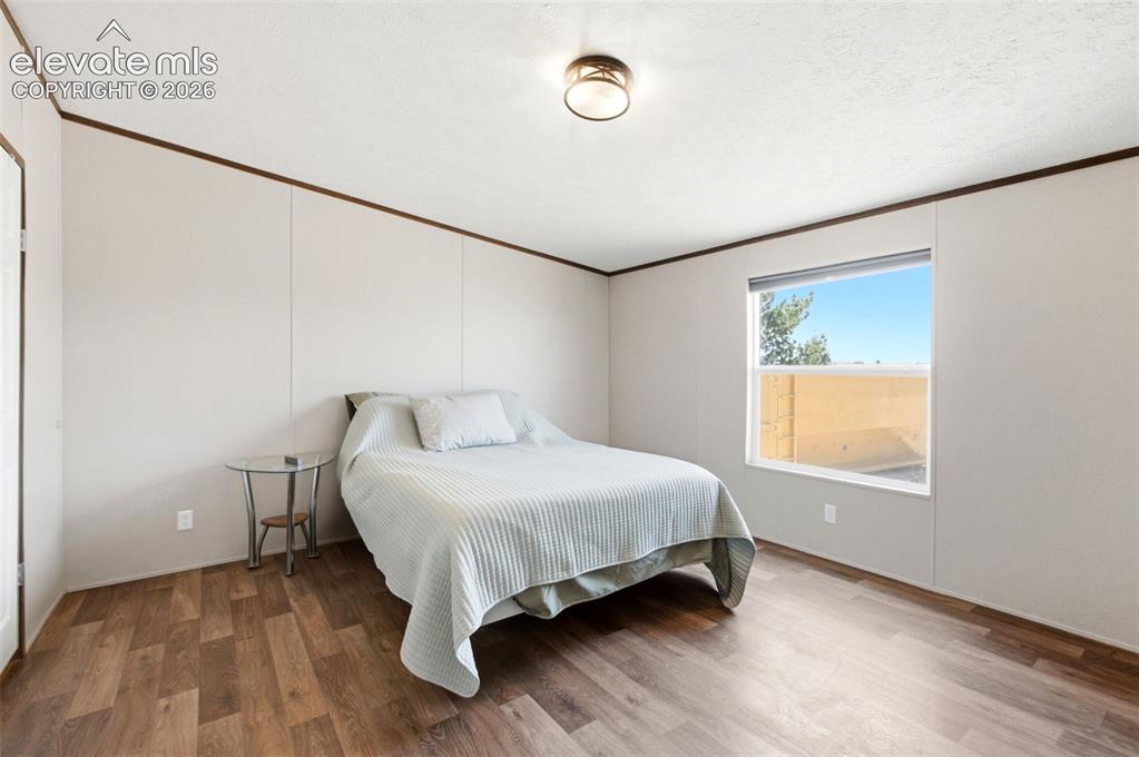 Image 9 of 32: Bedroom featuring wood-finish flooring, a ceiling-mounted light fixture, an