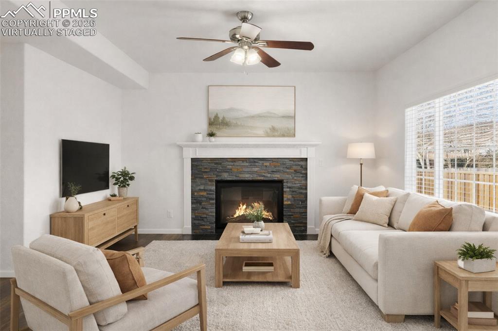 Image 3 of 37: Living area featuring a fireplace, ceiling fan, and wood finished floors. v
