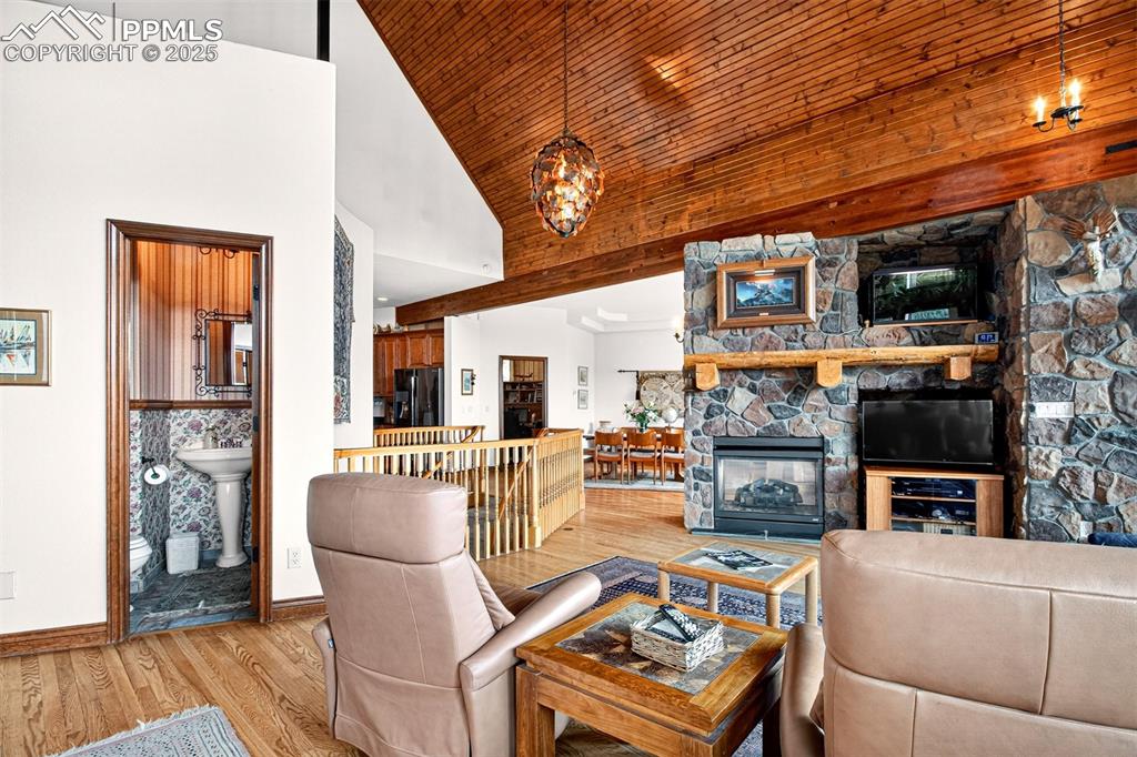 Image 11 of 50: Living room on main level with double sided gas fireplace, walk out to spac