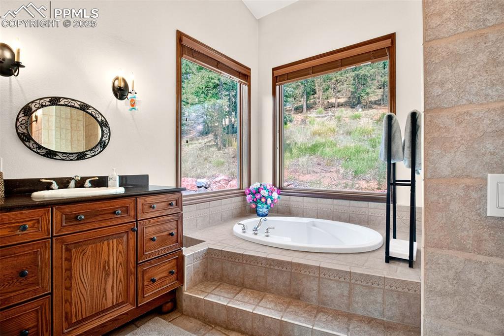 Image 17 of 50: Primary en suite 5 piece bathroom highlighting the soaking tub and private 