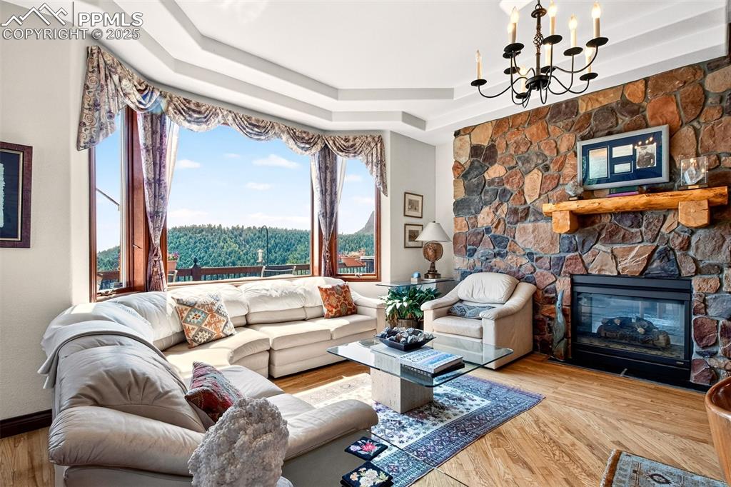 Image 21 of 50: Family room on main level with gas burning fireplace and large windows brin