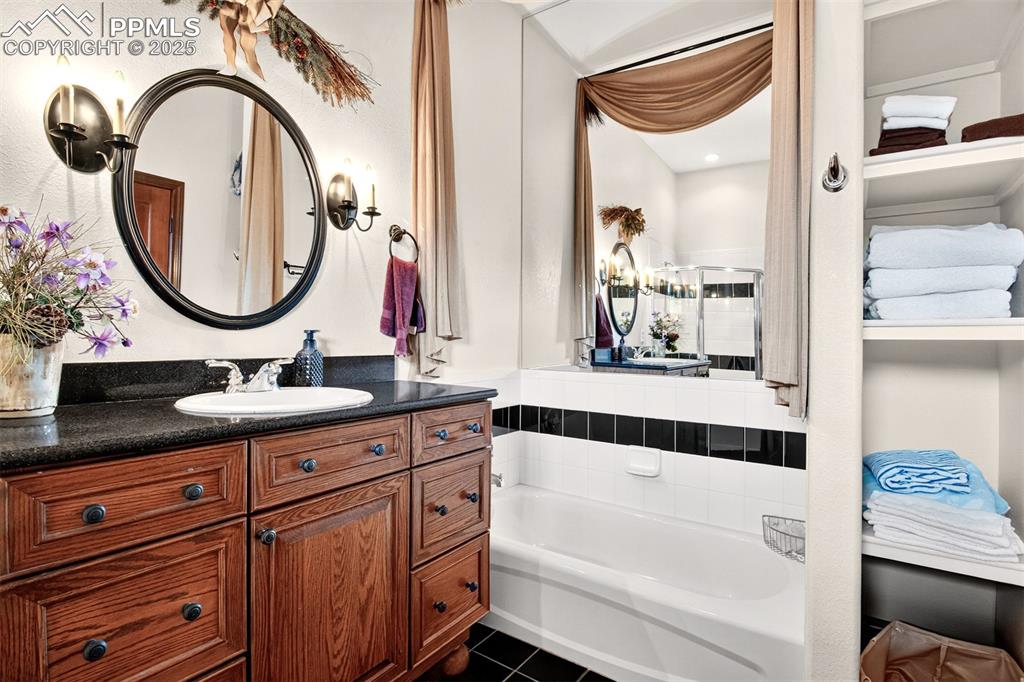 Image 45 of 50: Full bathroom on the lower level equipped with tub and stand alone shower 