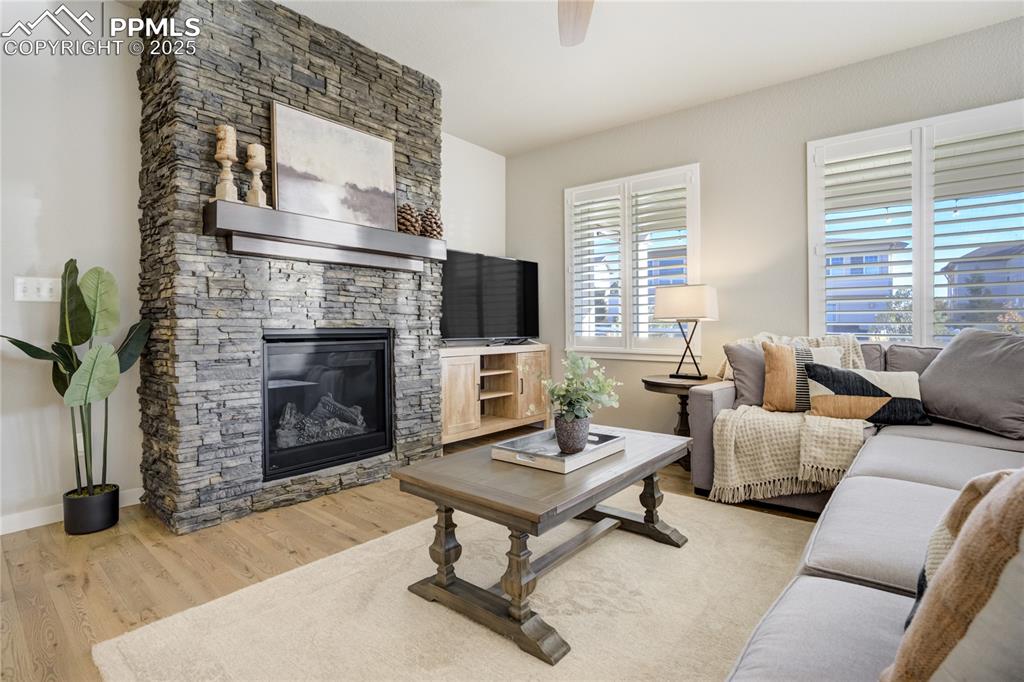 Image 4 of 50: Spacious and light-filled, anchored by a stone-surround gas fireplace and f