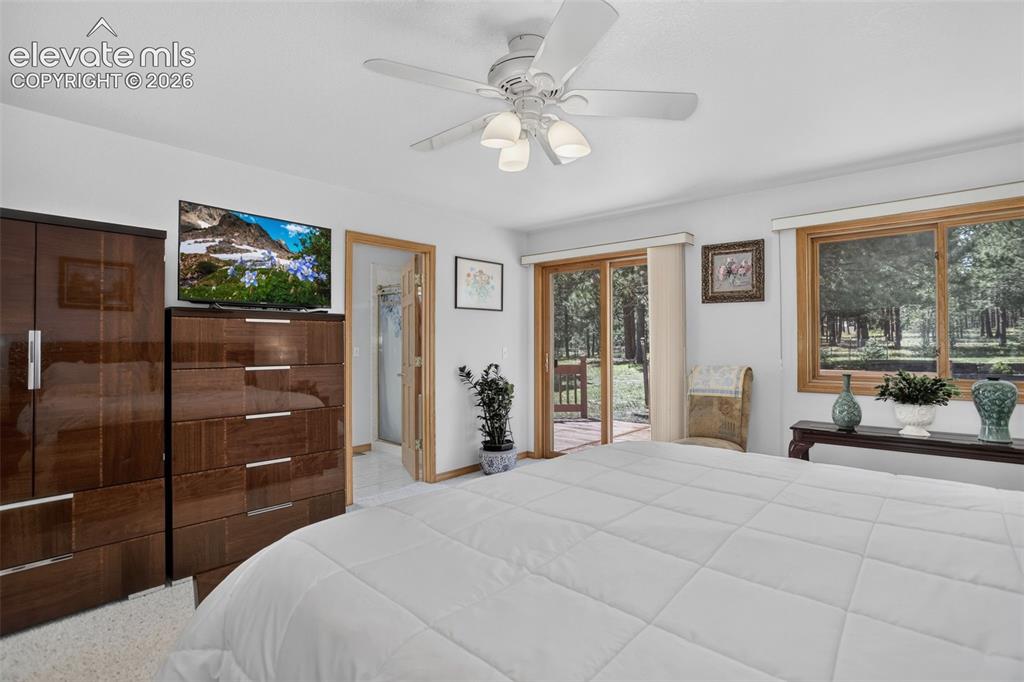 Image 24 of 49: Primary bedroom with walk out to back deck and en suite bathroom.