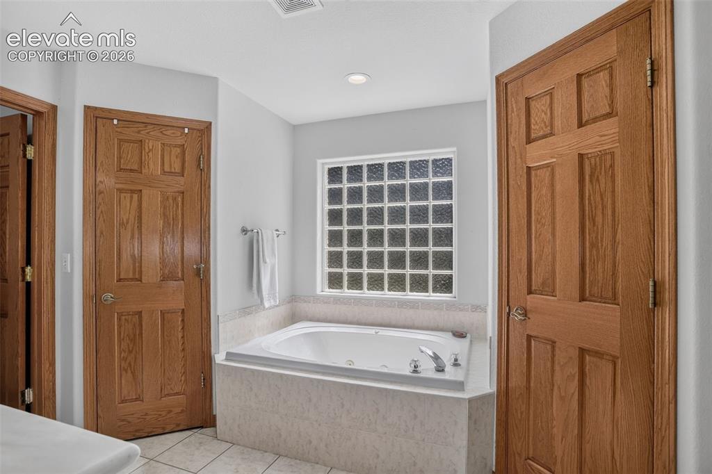 Image 26 of 49: Primary bathroom with jetted tub. 