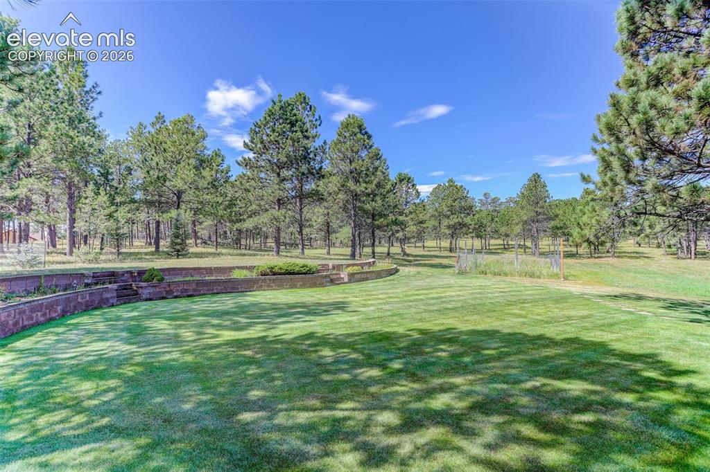 Image 6 of 49: Landscaped back yard with deer-proof fenced garden plot. 