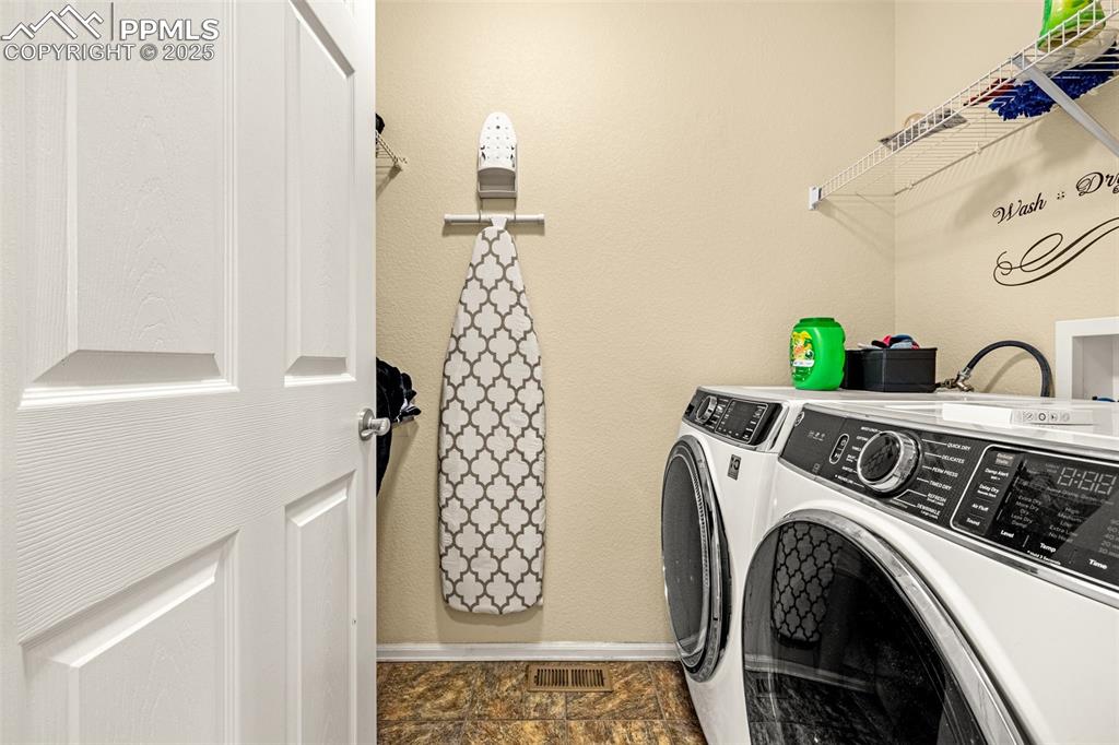 Image 14 of 36: Laundry room with independent washer and dryer and a textured wall